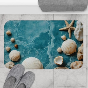 May include: A rectangular bath mat with a blue marble design, adorned with seashells, a starfish, and small stones. Gray knitted slippers are at the bottom left. A gray towel is at the top right.