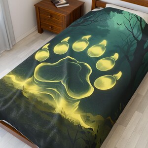 Könnte beinhalten: Eine Bettwäsche für ein Einzelbett mit einem leuchtenden Bärenpfotenabdruck in Gelb und Grün. Das Design umfasst eine Waldszene mit Bäumen und einer Fledermaussilhouette. Die Bettwäsche ist aus weichem Stoff.
