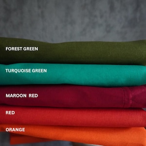 Könnte beinhalten: Ein Stapel gefalteter Stoffe in verschiedenen Farben: Waldgrün, Türkisgrün, Weinrot, Rot und Orange. Der Markenname "Prisha" ist unten zu sehen. Der Stoff scheint ein weiches Material zu sein.