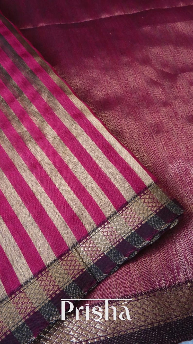 May include: Close-up of a fabric with vertical stripes in shades of pink and beige. The fabric has a decorative border with gold and dark purple accents. The word "Prisha" is visible in white text.