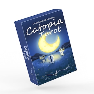 Puede incluir: Una baraja de cartas de tarot azul marino titulada "Catopia Tarot". La caja presenta una ilustraci&oacute;n caprichosa de tres gatos de dibujos animados bajo una luna creciente. Tambi&eacute;n se ve el texto "A 78-Cards Deck with instructions".