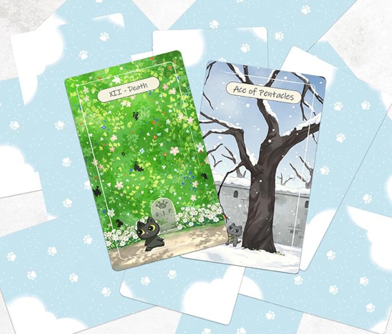 Puede incluir: Dos cartas de tarot con ilustraciones de un gato negro junto a una l&aacute;pida y un gato gris cerca de un &aacute;rbol nevado. Las cartas est&aacute;n sobre un fondo azul claro con patrones de nubes blancas y huellas de patas. Las cartas est&aacute;n etiquetadas como "XII - Death" y "Ace of Pentacles."