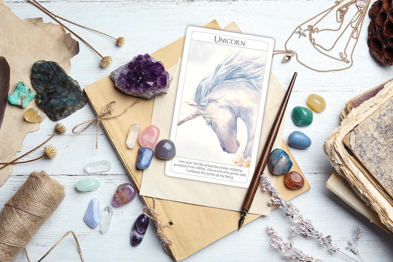 May include: A white card with a watercolor illustration of a unicorn with a silver horn. The card has the word "Unicorn" printed in black at the top and text below the image that reads "I am from the the untouched forest, walking  anywhere I wish. Like a unicorn with sad  eyes from velvet, I embrace the purity of my being."