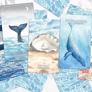 May include: A selection of oracle cards with watercolour illustrations of marine life. The cards depict a whale's tail, a pearl in an oyster, a whale, and an anchor. The cards are surrounded by blue patterned cards.