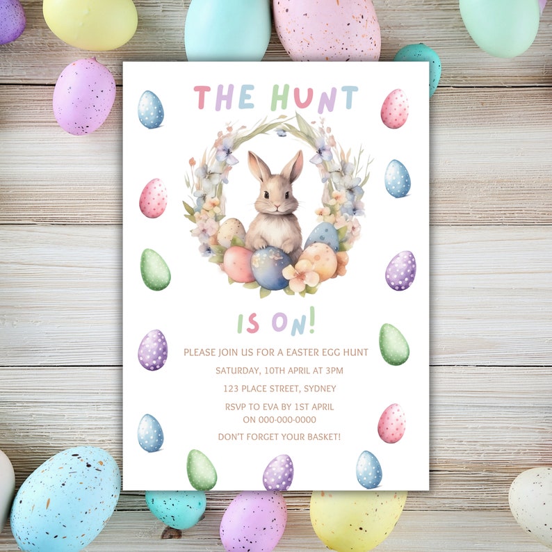 May include: A white invitation card with a colorful Easter bunny surrounded by eggs and flowers. The text on the card reads "The Hunt is On!" and includes details for an Easter egg hunt.