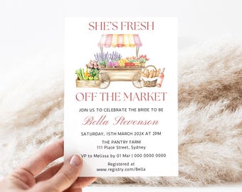 Op de afbeelding: Een aquarel-illustratie van een roze en witte marktkar vol met verse producten, bloemen en brood. De tekst "She's Fresh Off The Market" staat boven de kar, en de tekst "Join us to celebrate the bride to be Bella Stevenson" staat onder de kar. De tekst "Saturday, 15th March 202X at 2PM" staat onder de naam van de bruid. De tekst "The Pantry Farm 111 Place Street, Sydney" staat onder de datum. De tekst "VP to Melissa by 01 Mar | 000 0000 0000" staat onder het adres. De tekst "Registered at www.registry.com/Bella" staat onderaan de uitnodiging.