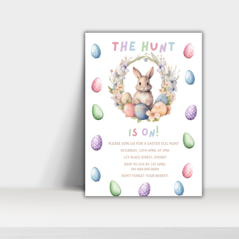 May include: An invitation to an Easter egg hunt with a watercolor illustration of a bunny rabbit sitting in a wreath of flowers and colorful eggs. The text reads "The Hunt is On!" with details about the event, including the date, time, location, RSVP information, and a reminder to bring a basket.