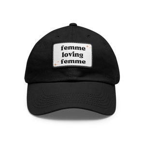 May include: Black baseball cap with a white patch that says "femme loving femme" in black text with orange stars.
