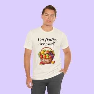 May include: White t-shirt with the text "I'm fruity. Are you?" and a basket of fruit printed on the front.