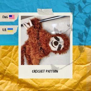 May include: A brown crochet sloth hanging from a metal bar. The sloth has a white face with dark brown eyes and a smiling mouth. The text "CROCHET PATTERN" is below the sloth.