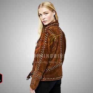 May include: Brown suede jacket with a studded design. The jacket has a zip fastening and a belt at the waist.