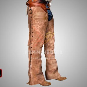 May include: Brown leather chaps with fringe detailing and decorative stitching. The chaps feature a wide belt and are designed to be worn over pants. The image shows the chaps from the waist down, showcasing the texture and style.
