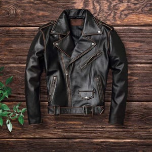 May include: A black leather motorcycle jacket with a zipper closure and a brown belt. The jacket has a classic biker style with a stand-up collar and zippered pockets.