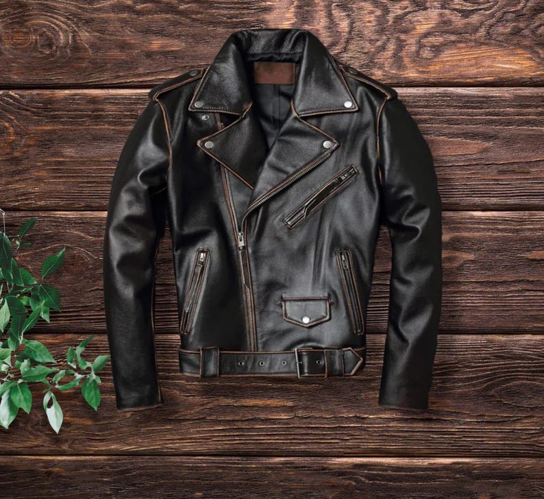 May include: A black leather motorcycle jacket with a zipper closure and a brown belt. The jacket has a classic biker style with a stand-up collar and zippered pockets.