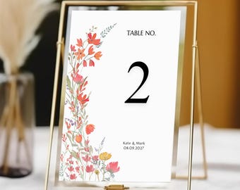 May include: A white table number card with a floral design in shades of orange, red, and yellow. The card reads "Table No. 2" and "Kate & Mark 08.09.2027".