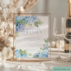 May include: A framed sign with the words "Signature Drinks" and drink recipes. The sign features blue hydrangea floral arrangements. The recipes include "Blueberry Basil Smash" and "Honeydew Mojito". The sign also includes the names "Kate & Mark" and the date "August 20, 2028".