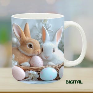 May include: White ceramic mug featuring a charming Easter design. The mug showcases two adorable bunnies nestled in a woven basket with pastel-colored Easter eggs. The word "DIGITAL" is printed in green on the bottom right.