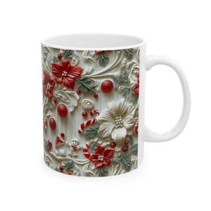 K&ouml;nnte beinhalten: Wei&szlig;e Keramiktasse mit festlichem Weihnachtsdesign. Die Tasse hat ein erhabenes Reliefmuster aus roten Weihnachtssternen, wei&szlig;en Blumen, Zuckerstangen und einem Schneemann auf cremefarbenem Hintergrund. Die Tasse hat einen wei&szlig;en Griff.