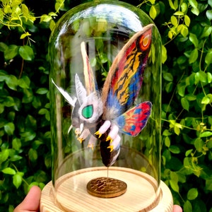 Tęczowa Mothra Chibi Mothra w dekoracjach Glass Dome.