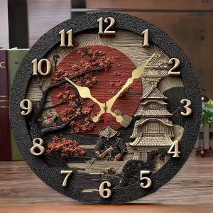 Op de afbeelding: Een ronde wandklok met een Japans thema. De klok heeft een zwarte, getextureerde rand, goudkleurige cijfers en gouden wijzers. De wijzerplaat toont een rode zon, een pagode, kersenbloesems en een samoeraifiguur.