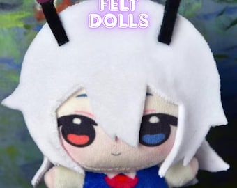 May include: A white felt doll with black antennae and red and blue eyes. The doll is wearing a blue and red outfit. The text "CUSTOM FELT DOLLS" is visible in the image.