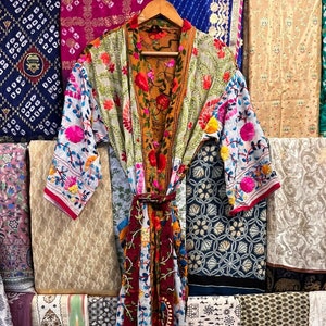 Könnte beinhalten: Eine farbenfrohe, mehrfarbige Kimono-Robe mit langen Ärmeln und einem Bindegürtel. Die Robe ist aus einem leichten Stoff gefertigt und mit aufwendigen Stickereien in Rosa-, Blau-, Grün- und Rottönen verziert.