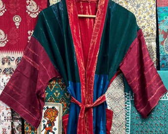 May include: A long, colorful robe with a tie belt. The robe is made of a patchwork of different fabrics in shades of red, green, blue, and white. The robe has a traditional Japanese kimono style.
