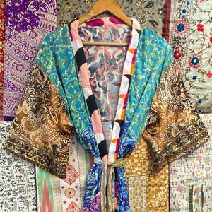May include: A blue, brown, pink, and white silk robe with a floral pattern. The robe has a sash tie and is made of patchwork fabric.
