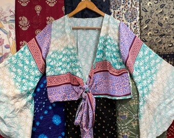 May include: A light blue and pink patterned kimono-style top with a tie front and long, wide sleeves. The top is made of a soft, flowing fabric and has a relaxed fit.