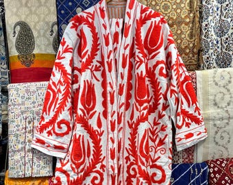 May include: A white long-sleeved robe featuring vibrant red embroidered floral and tulip patterns throughout the front and sleeves. The garment has an open front design, a straight hemline with side slits, and is displayed on a wooden hanger.