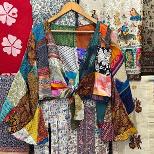 May include: A colourful patchwork kimono with a tie closure. The kimono is made of various fabrics in shades of blue, red, green, yellow, and brown. The kimono is a unique and stylish piece of clothing that can be worn for a variety of occasions.