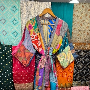 May include: A long-sleeved kimono-style robe crafted from a patchwork of various colorful fabrics featuring diverse patterns, including floral, geometric, and abstract designs. The garment includes a matching fabric tie belt at the waist.