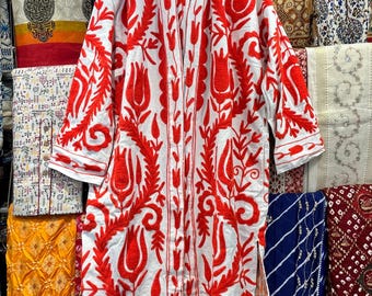 May include: A white cotton robe with red embroidered floral designs. The robe has a long, open front and long sleeves. The embroidery features stylized tulips and leaves.