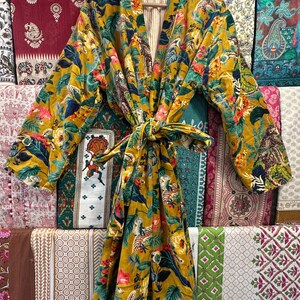 May include: A yellow and green floral print robe with a long sleeve and a tie belt. The robe is made of a soft, comfortable fabric and has a relaxed fit.