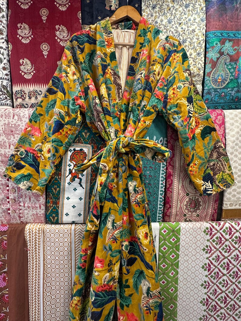 May include: A yellow and green floral print robe with a long sleeve and a tie belt. The robe is made of a soft, comfortable fabric and has a relaxed fit.
