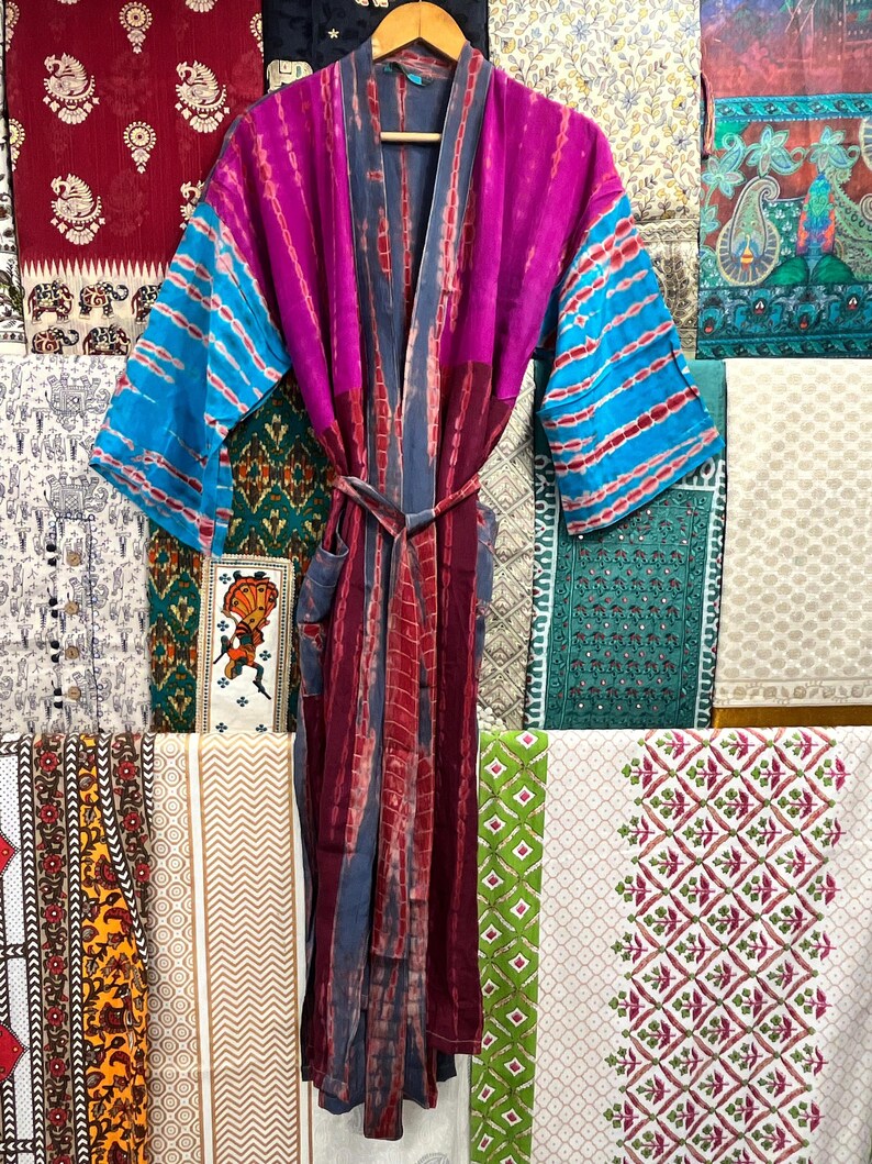 May include: A long, purple, blue, and gray silk robe with a tie belt. The robe has a tie belt and is made of a soft, flowing fabric.