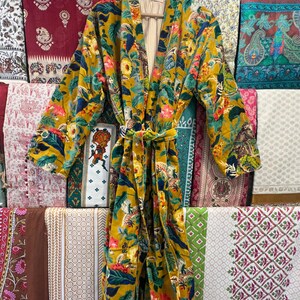 May include: A yellow, green, and blue floral print kimono robe with a long sleeve and a tie belt.