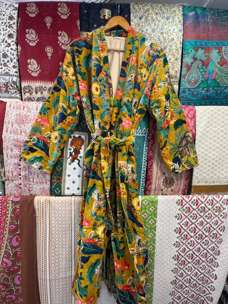 May include: A yellow, green, and blue floral print kimono robe with a long sleeve and a tie belt.