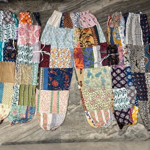 Puede incluir: Cinco pares de pantalones de patchwork en varios colores y patrones. Los pantalones están hechos de tela de algodón y tienen un corte holgado.