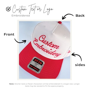 May include: A white and red baseball cap with the words "Custom Embroidery" embroidered in red. The cap has a red brim and a small red button on top. The text "Custom Text or Logo" is above the cap.