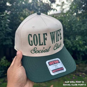 gifted custom hat that say golf wife social club in green thread, the hat is green and natural color.