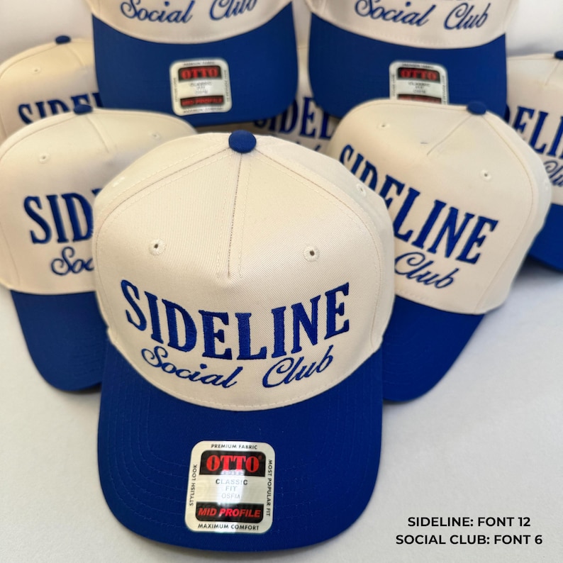 May include: Cream and blue baseball caps with the text "SIDELINE Social Club". The caps have a classic fit and a mid-profile design. The caps are made of premium fabric. Several caps are displayed.