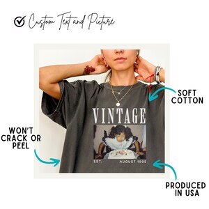 K&ouml;nnte beinhalten: Ein dunkelgraues T-Shirt mit dem Wort "Vintage" auf der Vorderseite. Das Shirt zeigt au&szlig;erdem ein Foto eines jungen M&auml;dchens, das einen Geburtstagskuchen h&auml;lt. Der Text "EST. AUGUST 1995" ist unter dem Foto gedruckt. Das Shirt ist aus weicher Baumwolle und wird in den USA hergestellt.
