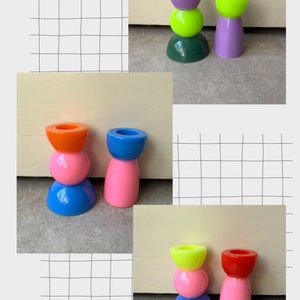 May include: Three sets of colorful stacked candle holders. The first set is green, yellow, and purple. The second set is blue, pink, and orange. The third set is blue, pink, and yellow.