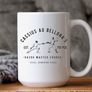 May include: White ceramic mug with a black and white logo that reads "Cassius Au Bellona's Est. 755 PCE -Razor Master Course- 'Steel Sharpens Steel'" and features two figures fencing.