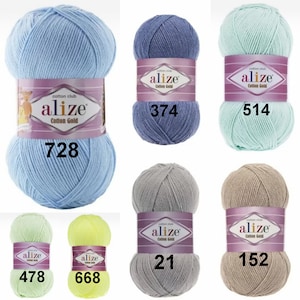 K&ouml;nnte beinhalten: Eine Auswahl an Alize Cotton Gold Garnkn&auml;ueln in verschiedenen Farben: Hellblau, Lavendel, Mintgr&uuml;n, Hellgr&uuml;n, Gelb, Grau und Beige. Jedes Kn&auml;uel hat ein Etikett mit dem Markennamen und einer Farbcode-Nummer.