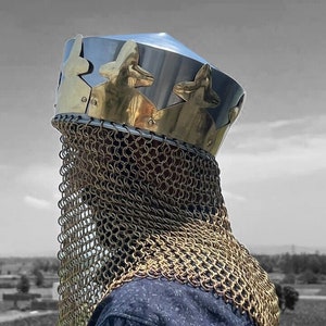 May include: A silver helmet with a gold crown and a chainmail coif. The helmet is pointed at the top and has a decorative design on the crown.