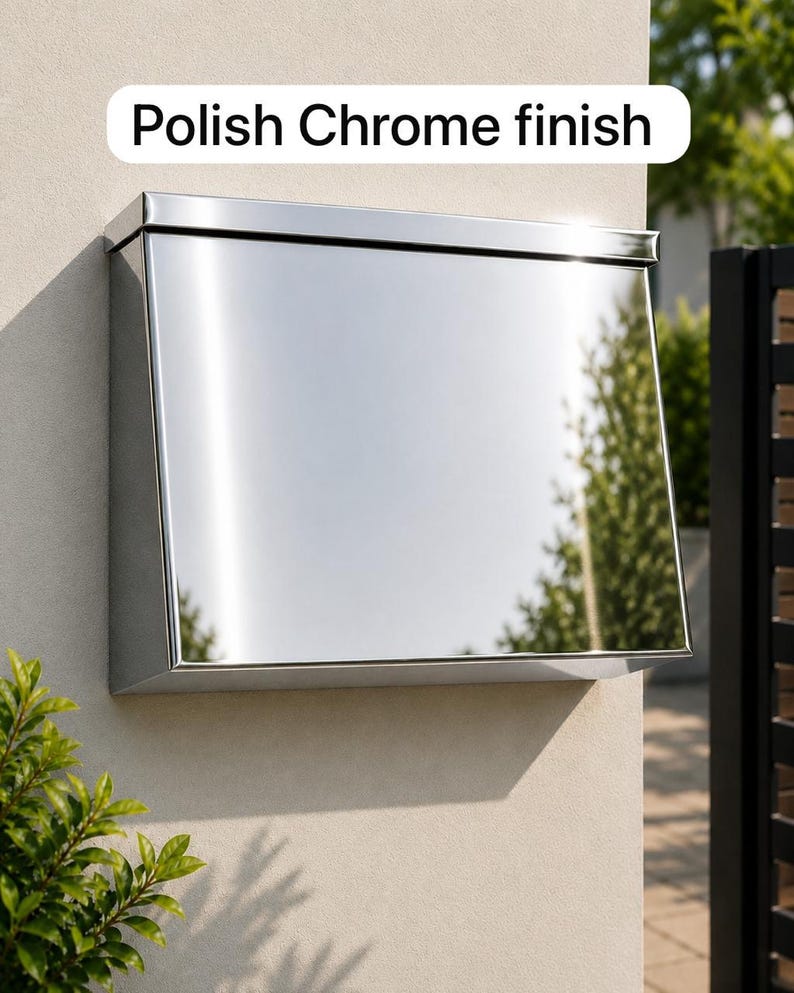 May include: A wall-mounted mailbox with a reflective polish chrome finish. The rectangular metal box features a flat top lid and a smooth, mirrored front surface. The text "Polish Chrome finish" is displayed in a white box above the mailbox.
