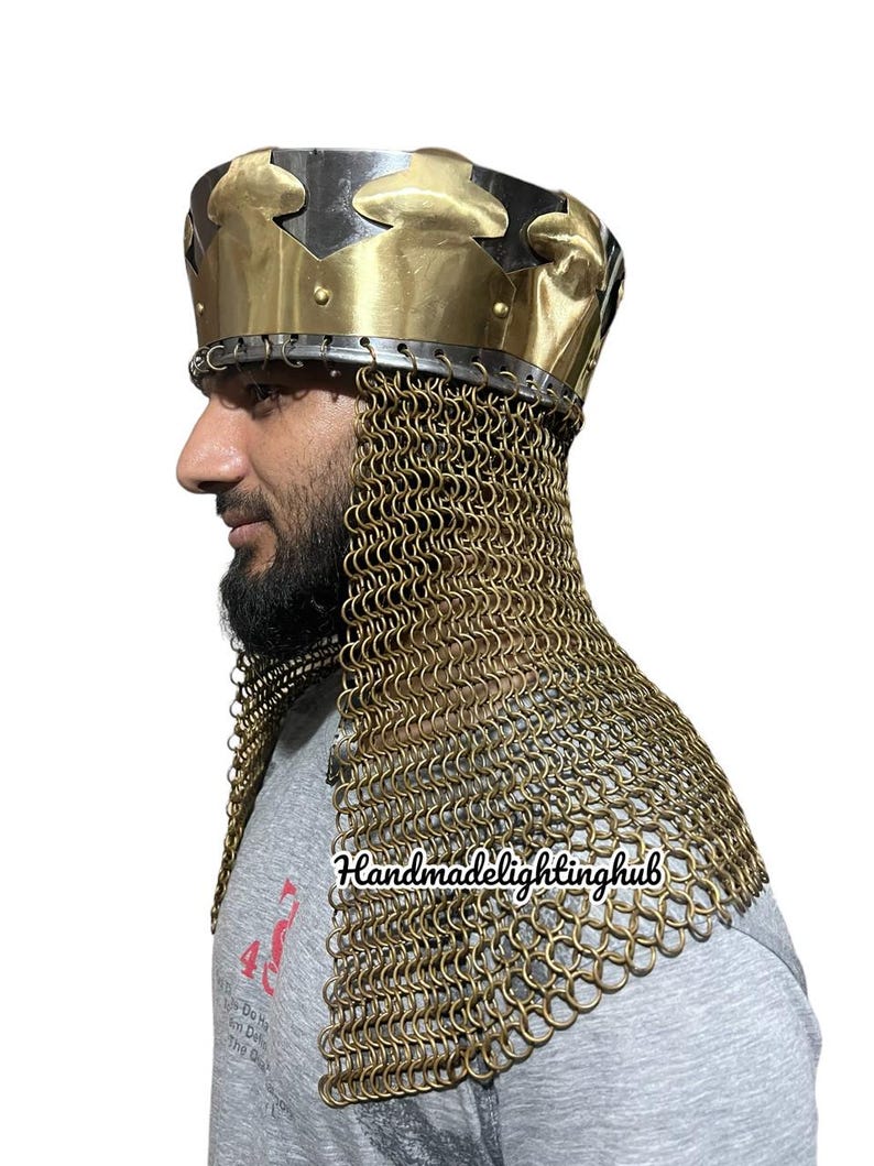 May include: A gold and black helmet with a chainmail coif. The helmet has a crown-like top with a decorative design. The chainmail coif covers the neck and shoulders.