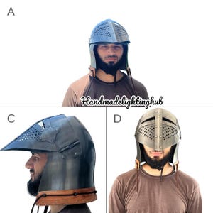 Pode incluir: Um conjunto de tr&ecirc;s capacetes medievais com um design rebitado e uma correia de queixo de couro. Os capacetes s&atilde;o de metal e t&ecirc;m um acabamento cinza escuro. Os capacetes s&atilde;o mostrados em tr&ecirc;s manequins diferentes que usam camisas marrons.